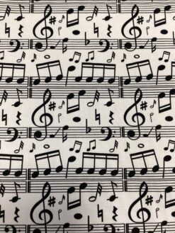 Tessuto misto cotone con motivo note musicali nere su fondo bianco.