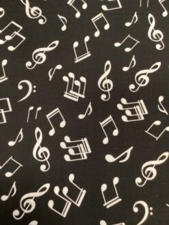 Tessuto misto cotone con motivo a note musicali bianche su sfondo nero.